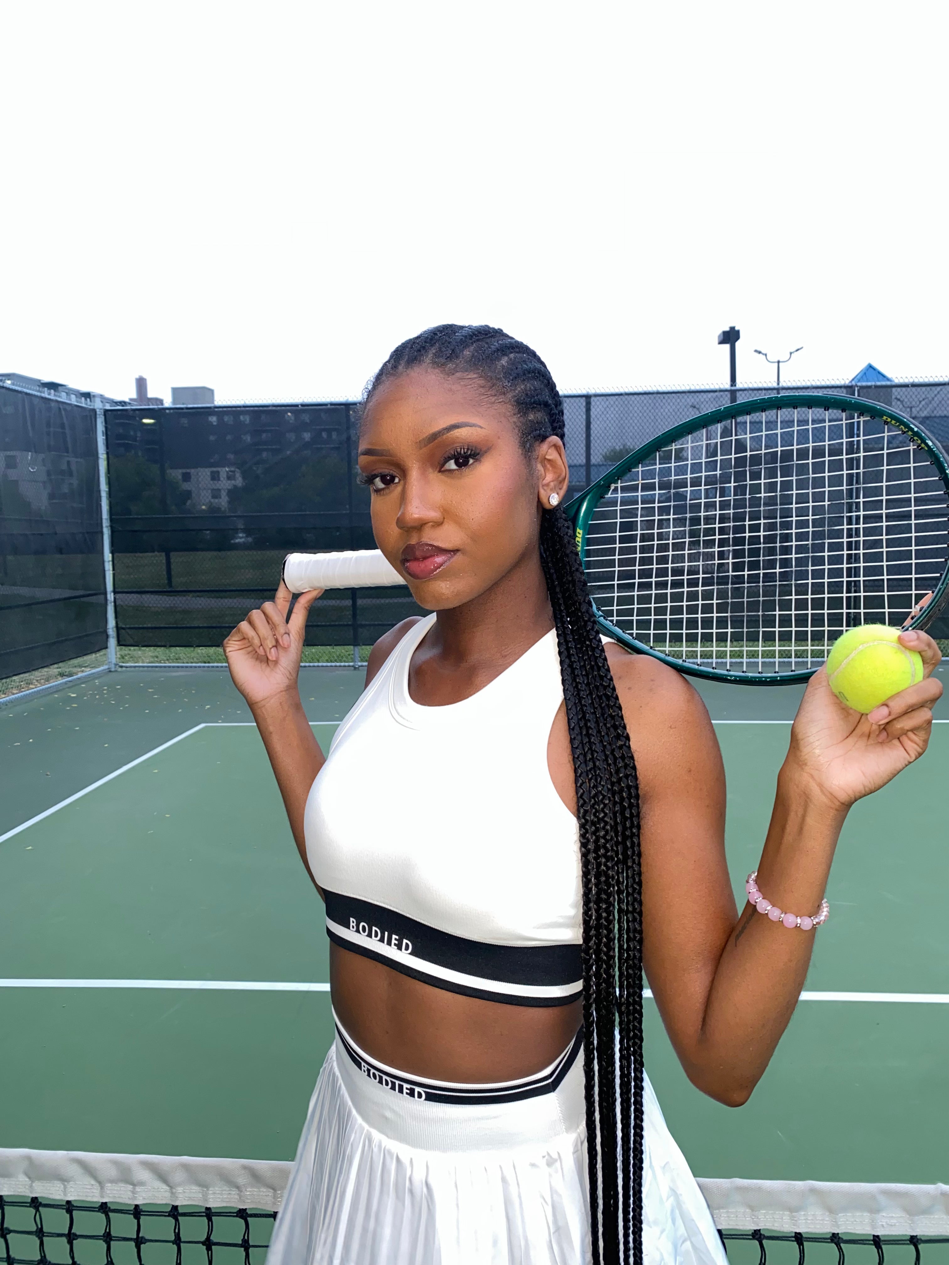 Woman holding a tennis racket and ball on a tennis court