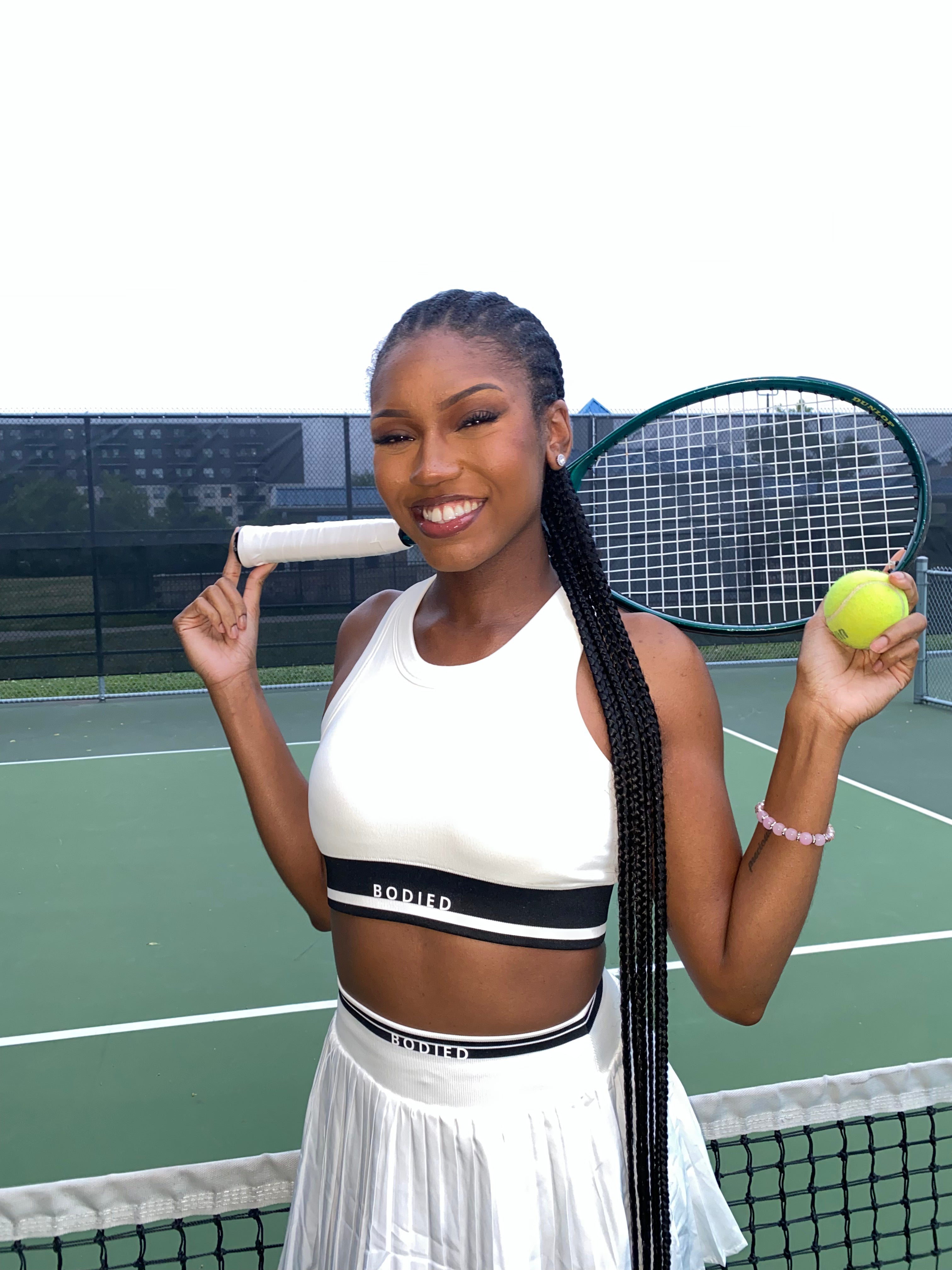 Woman holding a tennis racket and ball on a tennis court