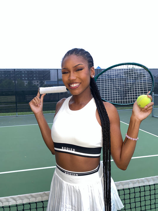 Woman holding a tennis racket and ball on a tennis court
