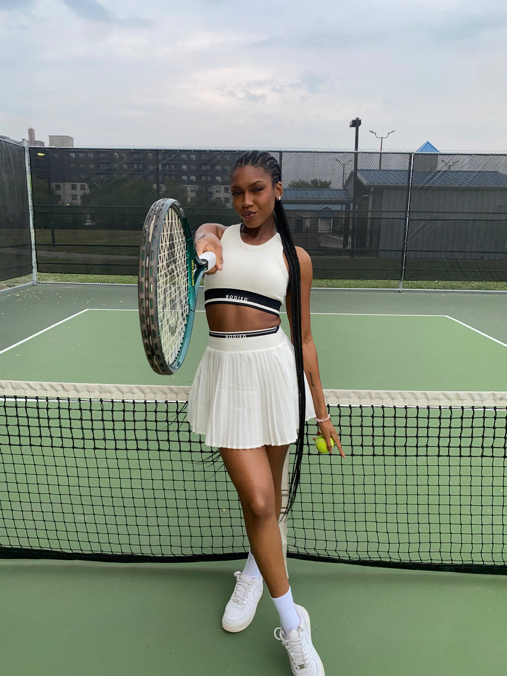 Woman holding a tennis racket and ball on a tennis court