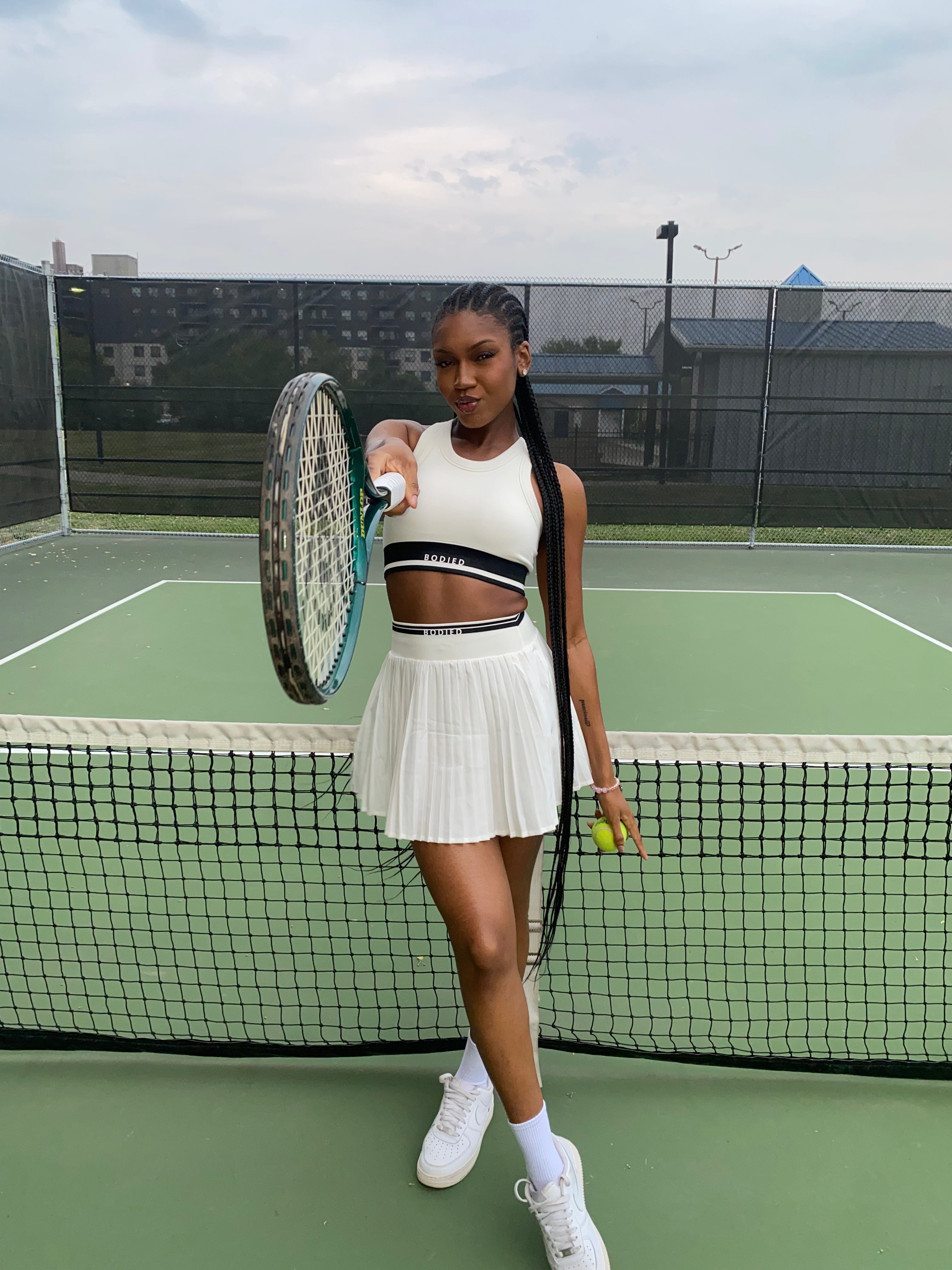 Woman holding a tennis racket and ball on a tennis court